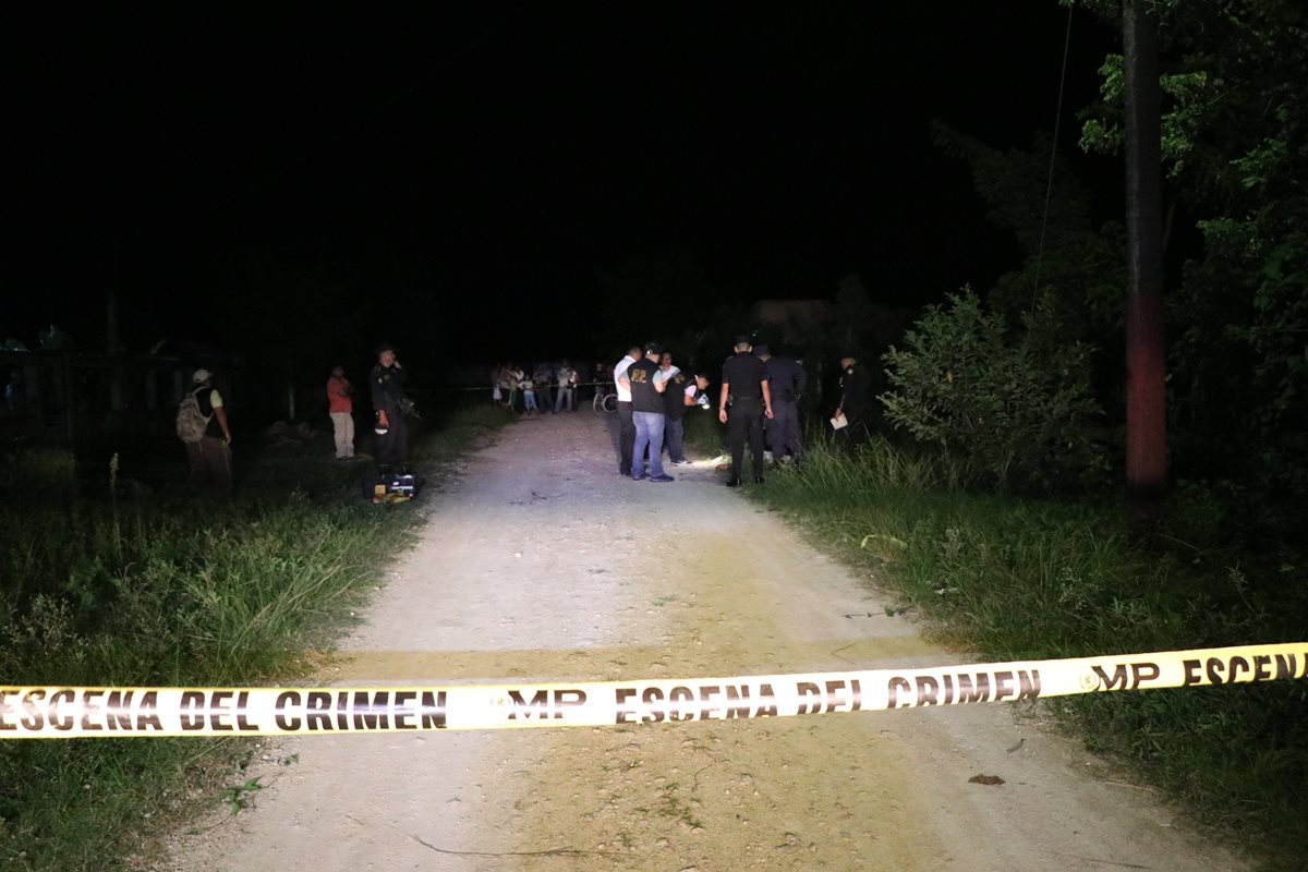 Fiscales del MP en el lugar donde ocurrió el crimen en un camino de terracería de Poptún, Petén. (Foto Prensa Libre: Rigoberto Escobar)