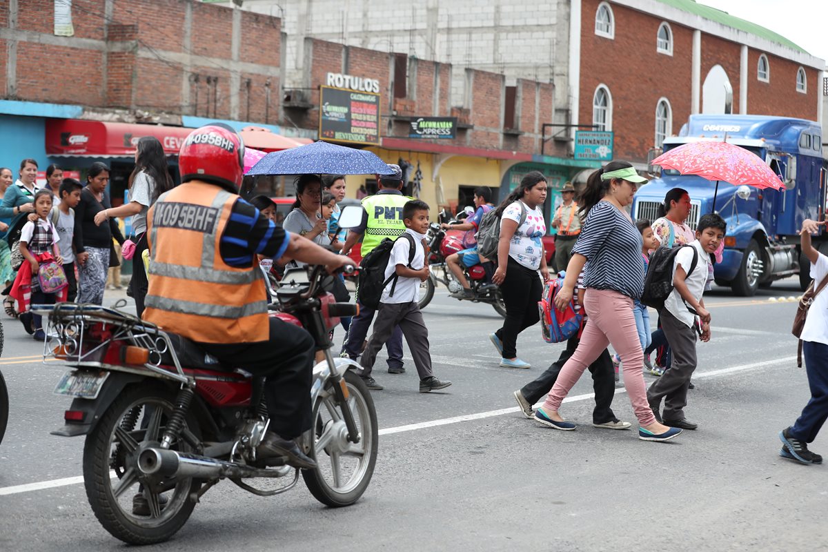 Ante la falta de una pasarela, niños y adultos se arriesgan al cruzar la carretera en el kilómetro 50 de la ruta Interamericana, El Tejar, Chimaltenango. (Foto Prensa Libre: César Pérez)