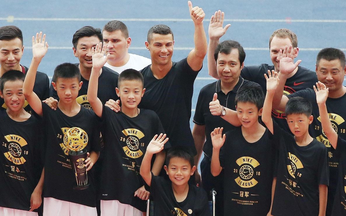 Cristiano Ronaldo comparte con unos niños en su visita a China la semana anterior. (Foto Prensa Libre: AFP).