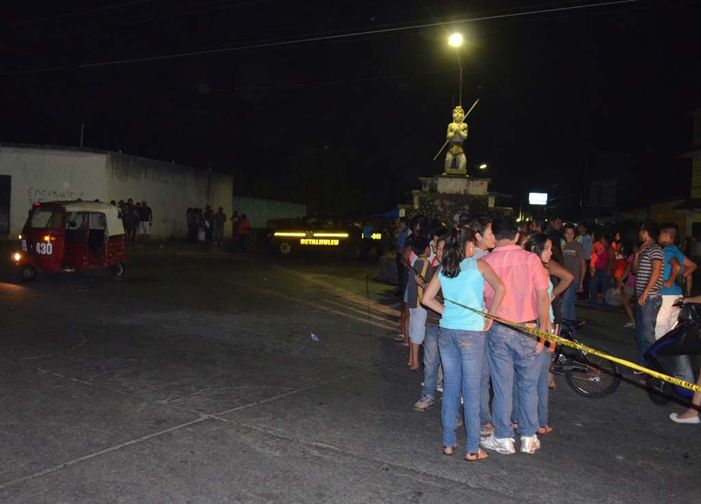 Curiosos observan el lugar donde quedó la unidad 430, donde fue atacado por sicarios el segundo mototaxista en menos de una semana en Retalhuleu. (Foto Prensa Libre: Jorge Tizol).