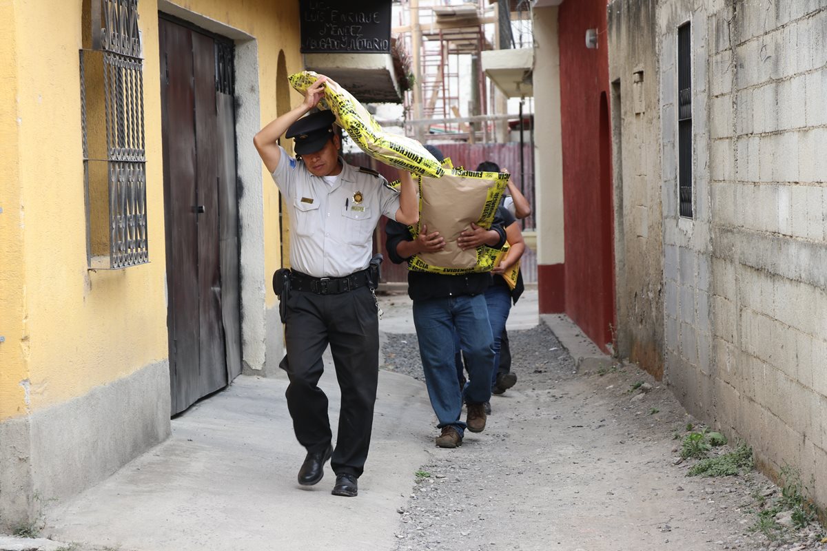 Agentes de la Policía Nacional Civil (PNC) incautan evidencias durante uno de los allanamientos. (Foto Prensa Libre: Renato Melgar)