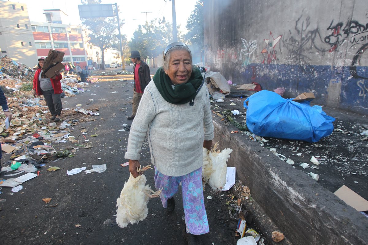Josefina Bethancourt carga con las gallinas que recogió del basurero (Foto Prensa Libre: Erick Ávila)