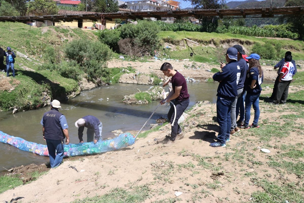 Los estudiantes y personal del Marn colocaron la biobarda sobre el río Xequijel. (Foto Prensa Libre: María José Longo)