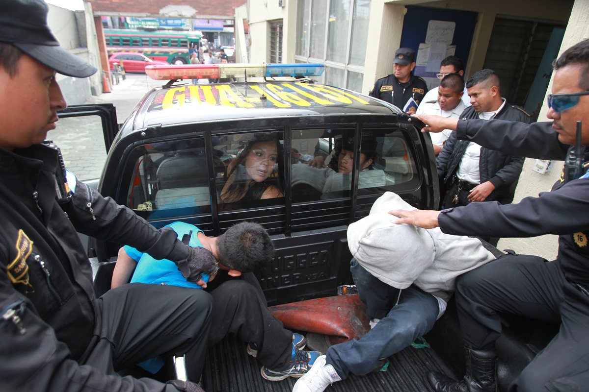 La mujer increpa desde la cabina de la autopatrulla a los dos menores, mientras son trasladados al Juzgado de Mixco por la PNC. (Foto Prensa Libre: Estuardo Paredes)