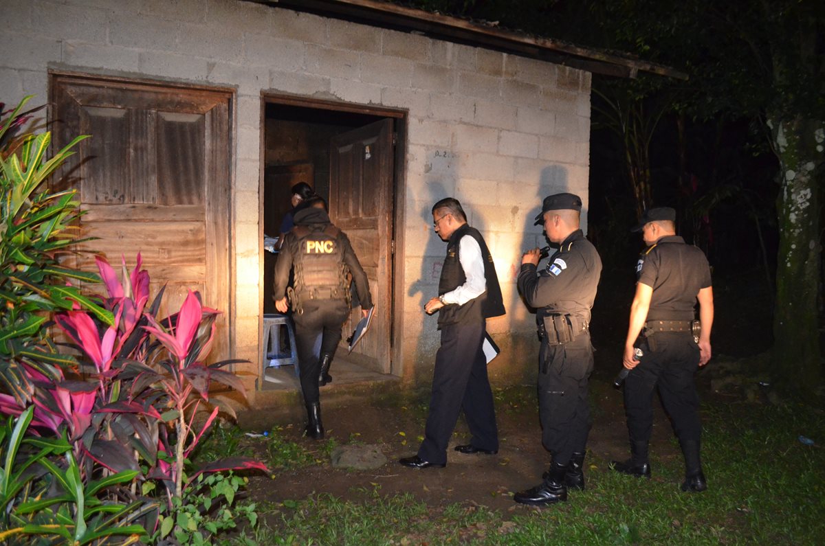 Agentes de la PNC resguardan vivienda en la que fue hallado el cadáver de un hombre, atacado con arma cortante en San Felipe. (Foto Prensa Libre: Jorge Tizol)