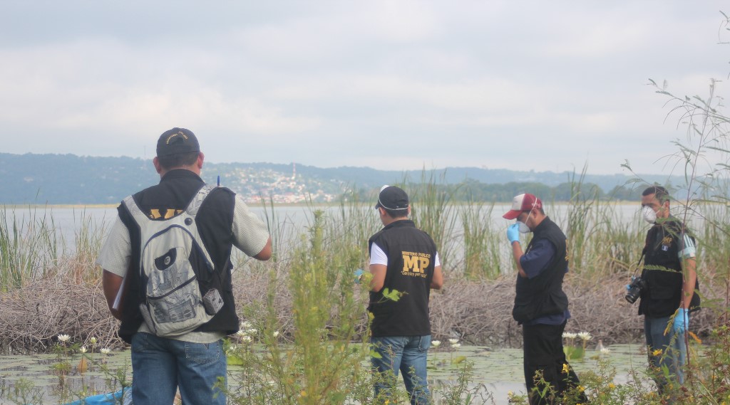 Investigadores reúnen evidencias en el lugar del hallazgo del cadáver. (Foto Prensa Libre: Rigoberto Escobar).