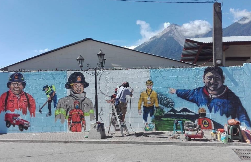 El mural recuerda a dos bomberos voluntarios y a Juan Galindo, delegado de la Conred, quienes murieron durante la erupción. (Foto Prensa Libre: Cortesía Denis David Sulecio).