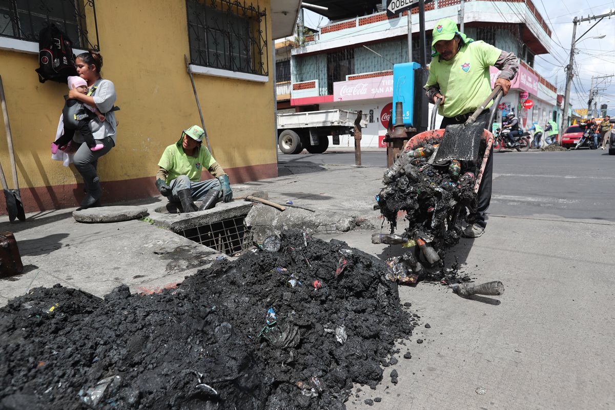 Empleados de la comuna capitalina extraen gran cantidad de desechos sólidos de una alcantarilla, en la zona 6. (Foto Prensa Libre: Érick Ávila)