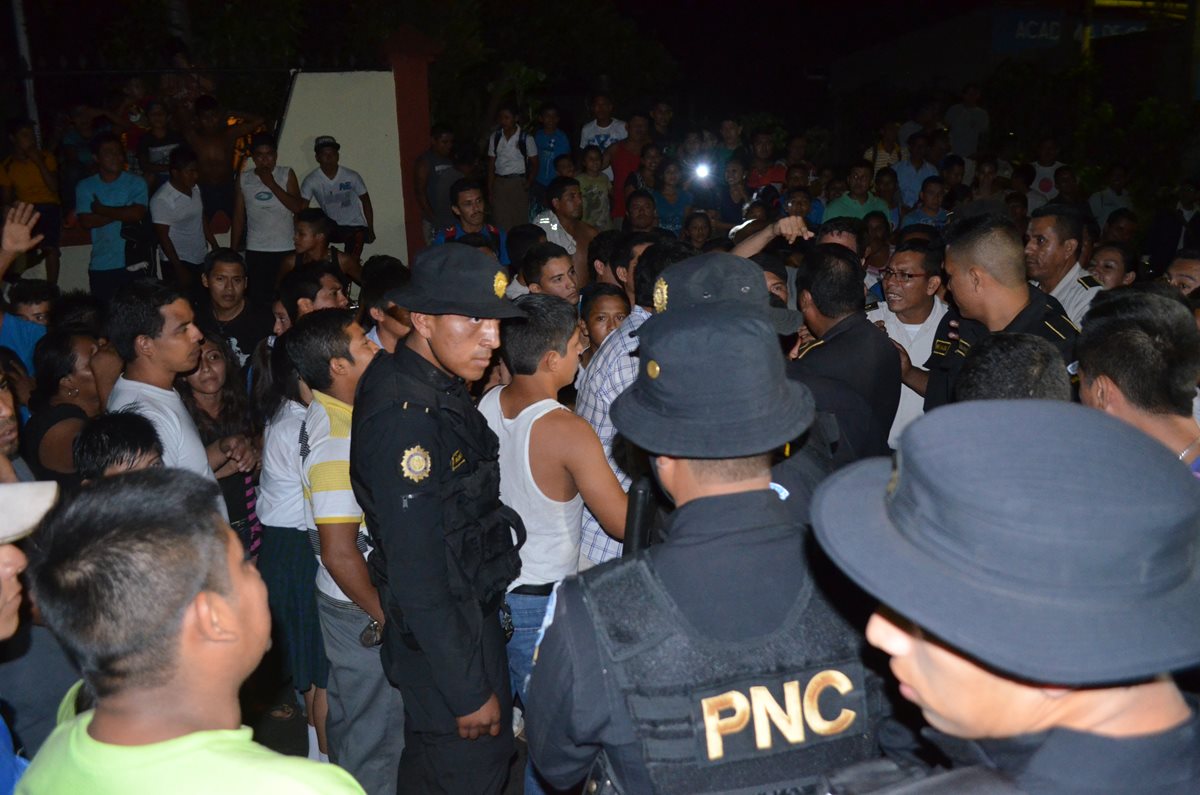 Agentes de la PNC dialogan con pobladores para liberar a sus compañeros. (Foto Prensa Libre: Jorge Tizol)