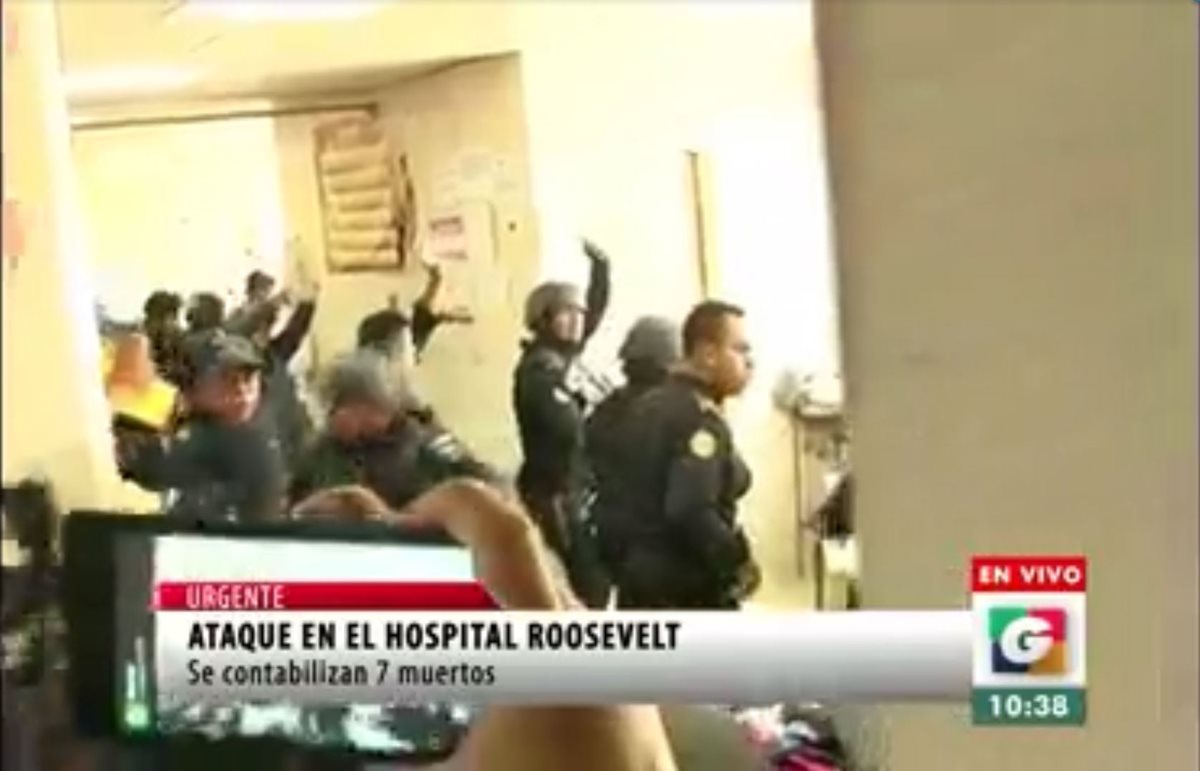 Momento en que la policía busca a un sospechoso en un baño del Roosevelt. (Foto Prensa Libre: Guatevision)