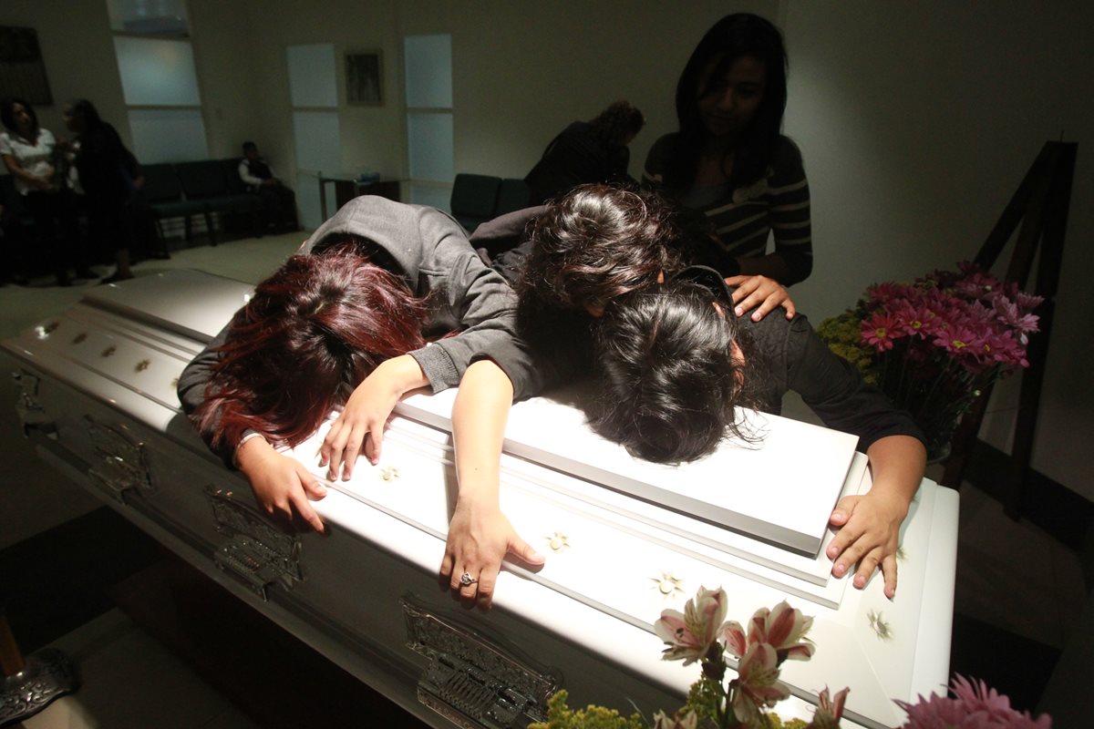 Familiares lloran sobre el ataúd de Brenda Dominguez, quien murió el sábado y fue inhumada el domingo. (Foto Prensa Libre: Estuardo Paredes)