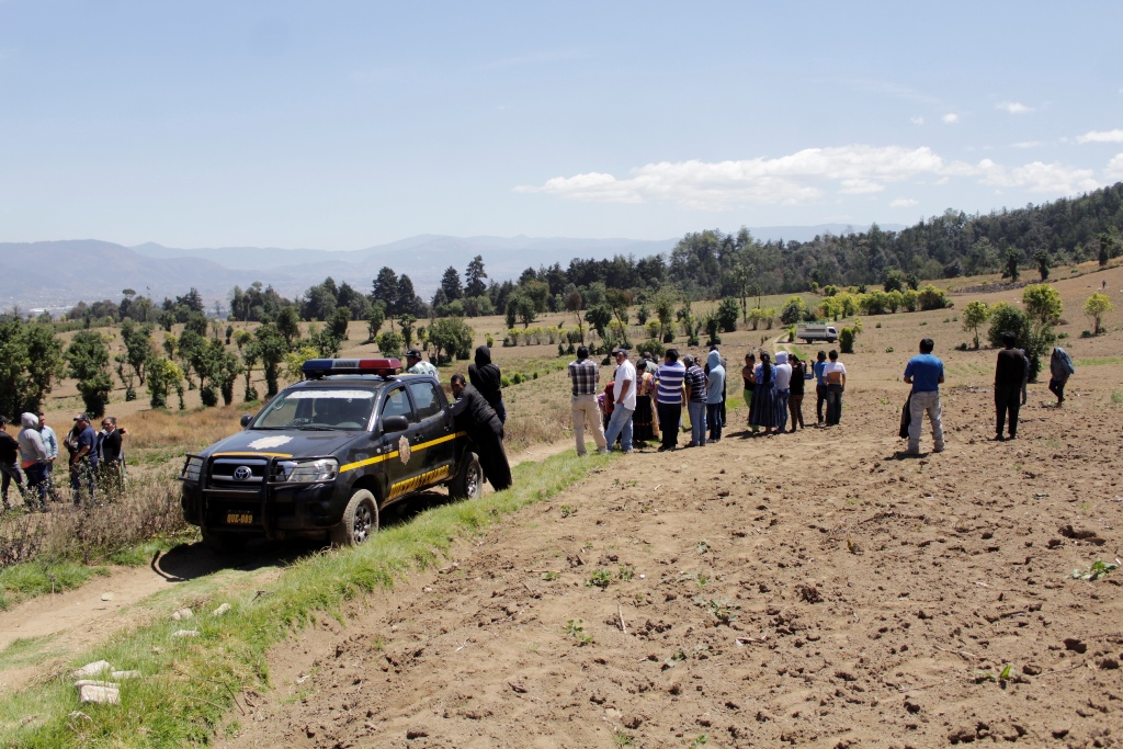 Vecinos de San Mateo, Quetzaltenango, observan el lugar donde fue hallado el cuerpo de una mujer con señales de violencia. (Foto Prensa Libre: María José Longo)