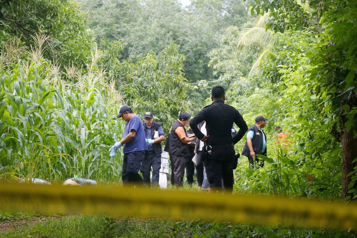 Oficiales de PNC inspeccionan el área donde hallaron los dos cuerpos. (Foto Prensa Libre: Rolando Miranda)