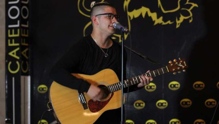 Diego Guzmán durante su participación con guitarra durante el certamen de talla mundial. (Foto Prensa Libre: Mike Castillo)