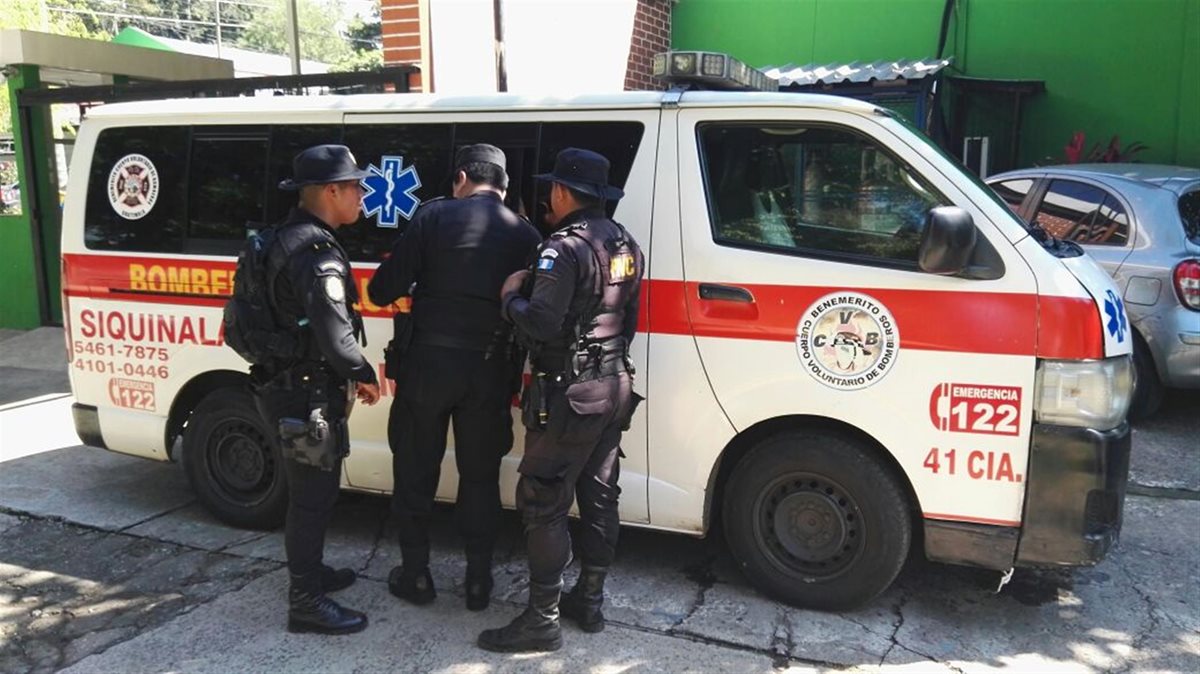 Agentes de la PNC resguardan ambulancia en la que era trasladado una de las víctimas del enfrentamiento armado en Siquinalá. (Foto Prensa Libre: Carlos E. Paredes)