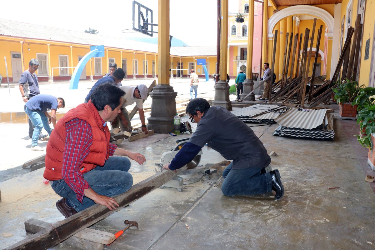 Padres de familia, estudiantes y maestros trabajan en la elaboración de estructuras de madera para el muro que circulará el área restringida en el Invo, en Xela. (Foto Prensa Libre: Carlos Ventura)