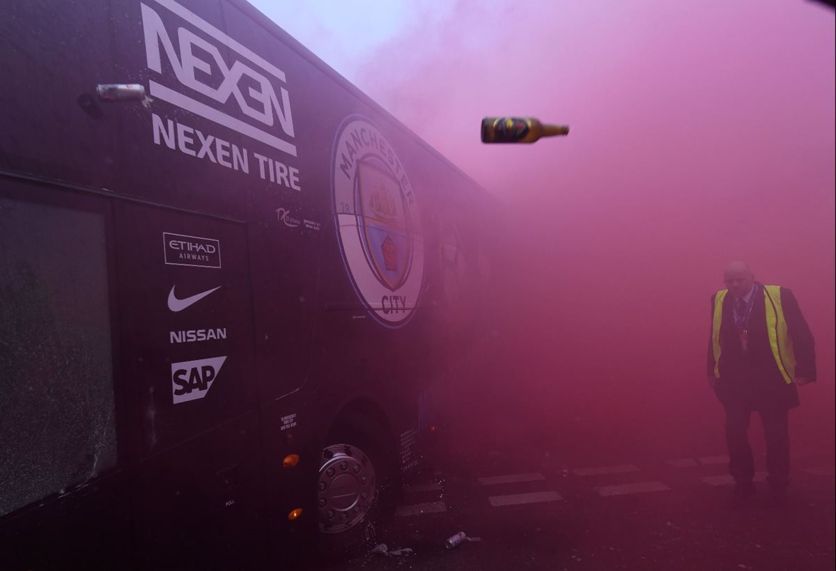 El bus del Mánchester City sufrió daños en su llegada al estadio del Liverpool por un grupo de aficionados. (Foto Prensa Libre: AFP).