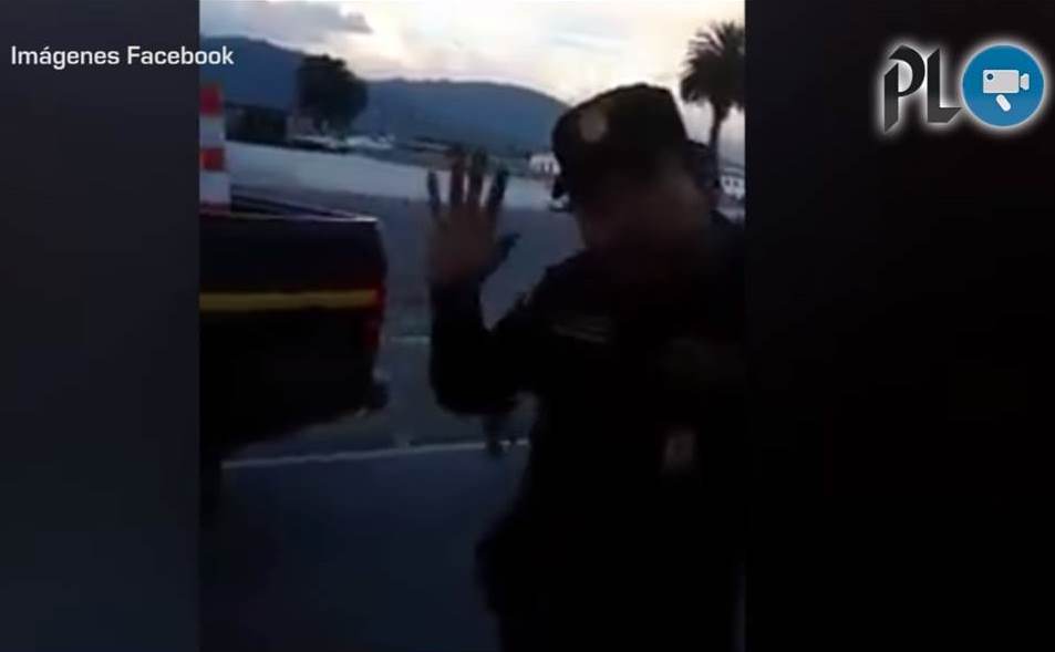 Un agente de la PNC muestra una seña obscena luego de discusión con vecinos de Xela. (Foto Prensa Libre: Facebook)