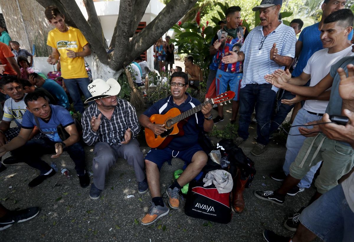 Un grupo de migrantes cantan en contra del gobierno hondureño en Tecún Umán, San Marcos. (Foto Prensa Libre: EFE)