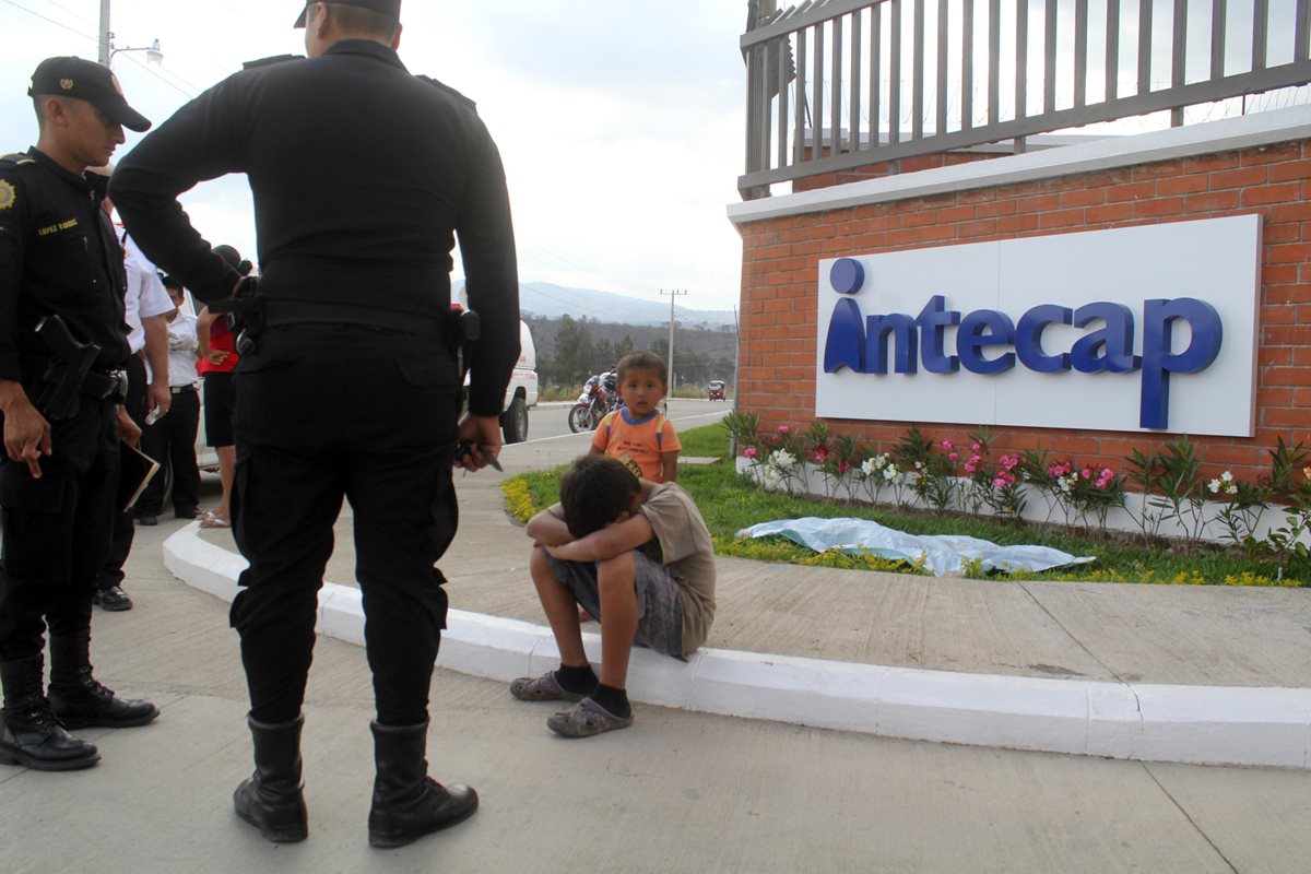 Agentes de la PNC observan a uno de los hermanos de la víctima, frente a las instalaciones del Intecap en Jalapa. (Foto Prensa Libre: Hugo Oliva)
