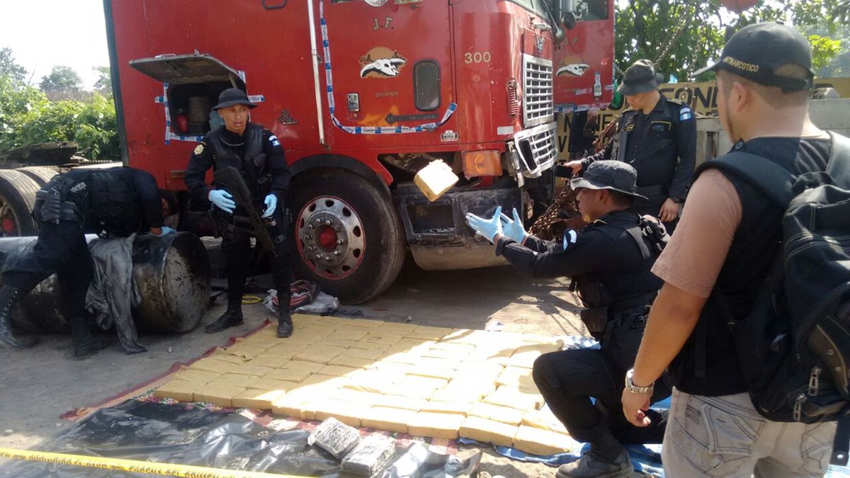 Agentes antinarcóticos extraen paquetes con droga hallados en tráiler, en la cabecera de Retalhuleu. (Foto Prensa Libre)