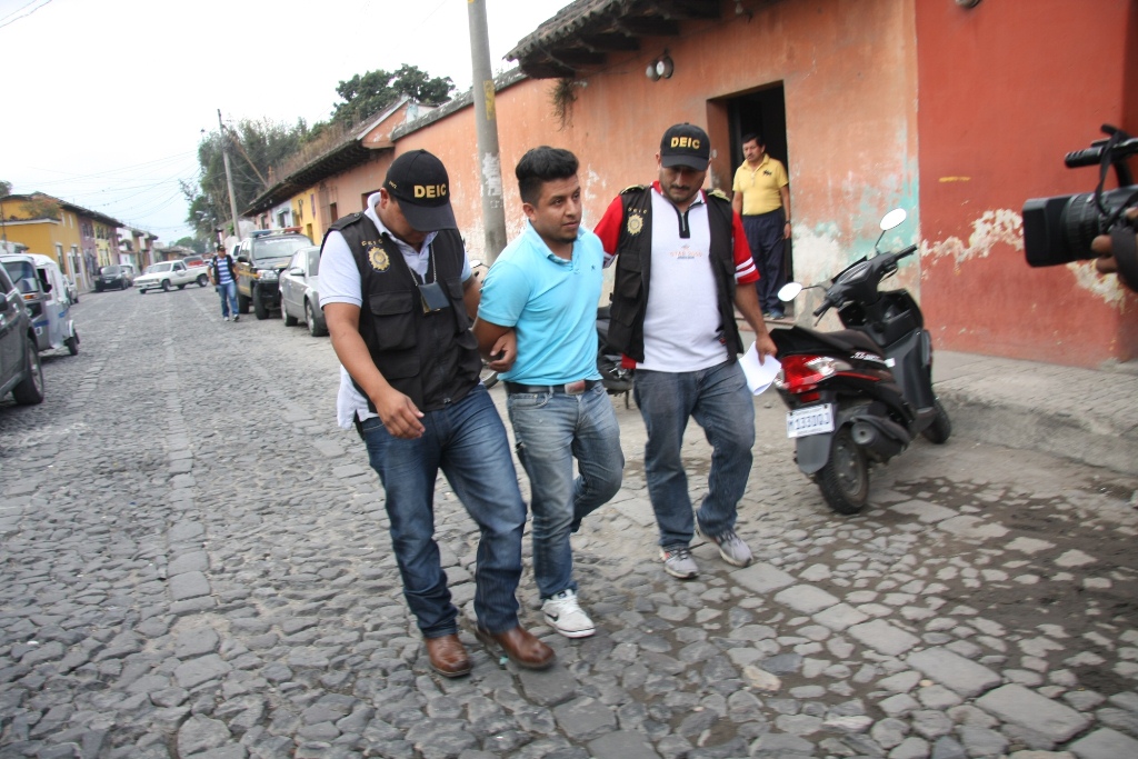 Investigadores trasladan al sindicado del crimen. (Foto Prensa Libre: Renato Melgar).