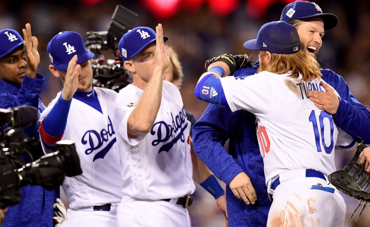 Clayton Kershaw celebra con Justin Turner #10 el primer triunfo de los Dodgers en la Serie Mundial. (Foto Prensa Libre: AFP)