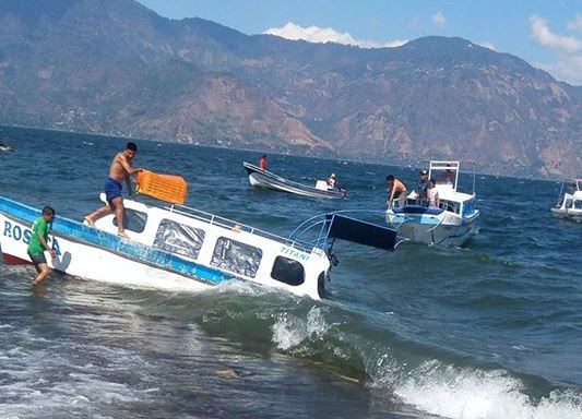 Lancha llega con dificultad a las playas del Lago de Atitlán, Sololá, debido a las condiciones climáticas que afectaron el lugar. (Foto Prensa Libre: Facebook Jaime Castro Galindo)