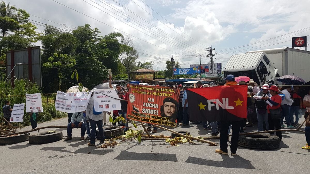 Salubristas mantienen bloqueado el paso de vehículos en el km 244 de la ruta al Atlántico, Morales Izabal. (Foto Prensa Libre: Dony Stewart)