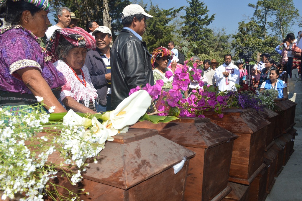 Pobladores observan algunos de los ataúdes que contienen los restos de las víctimas del conflicto armado en Uspantán. (Foto Prensa Libre: Óscar Figueroa).