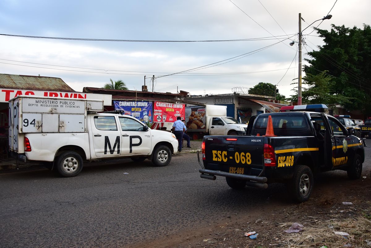 Autoridades del MP y la PNC frente al comercio en el que fue ultimado Nery Cermeño. (Foto Prensa Libre: Carlos Paredes)