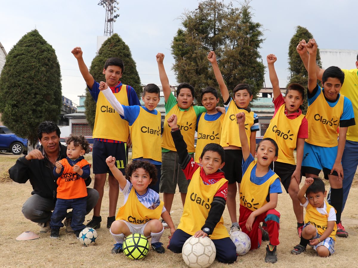 El entrenador Francisco Batres junto a algunos de los menores que practican futbol en la academia Cosmos Copesur. (Foto Prensa Libre: Raúl Juárez).