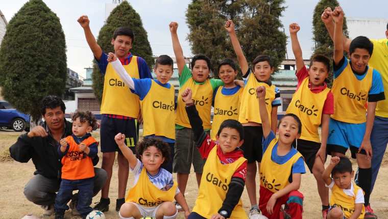 El entrenador Francisco Batres junto a algunos de los menores que practican futbol en la academia Cosmos Copesur. (Foto Prensa Libre: Raúl Juárez).