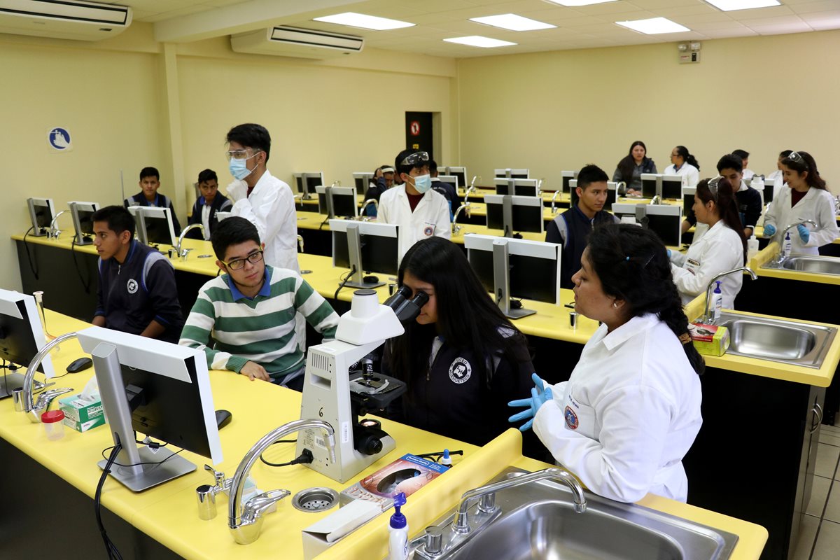 Estudiantes universitarios (de blanco) instruyen a un grupo de alumnos del nivel medio durante una feria académica efectuada en la sede de la Universidad Mariano Gálvez de Huehuetenango. (Foto Prensa Libre: Mike Castillo)