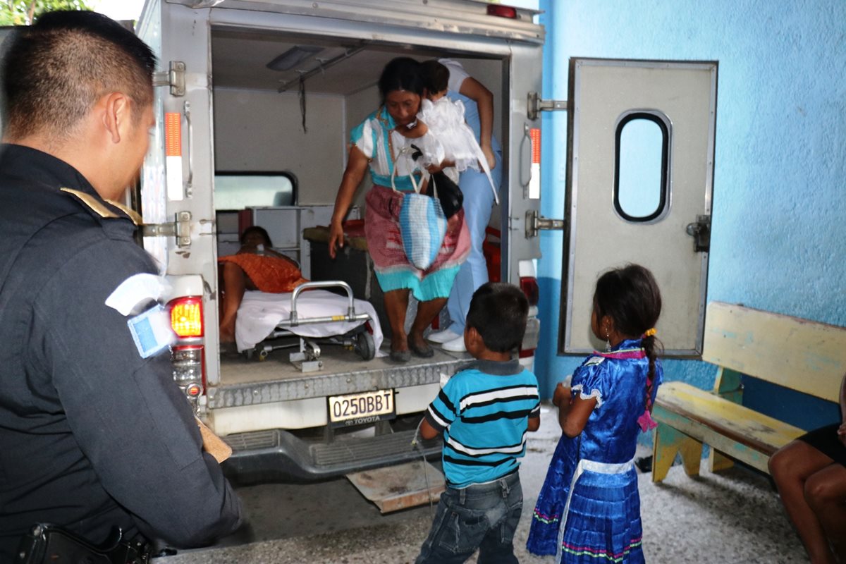 Los dos menores observan a su mamá, quien permanece en una camilla en la ambulancia, en Chiquimula. (Foto Prensa Libre: Mario Morales).