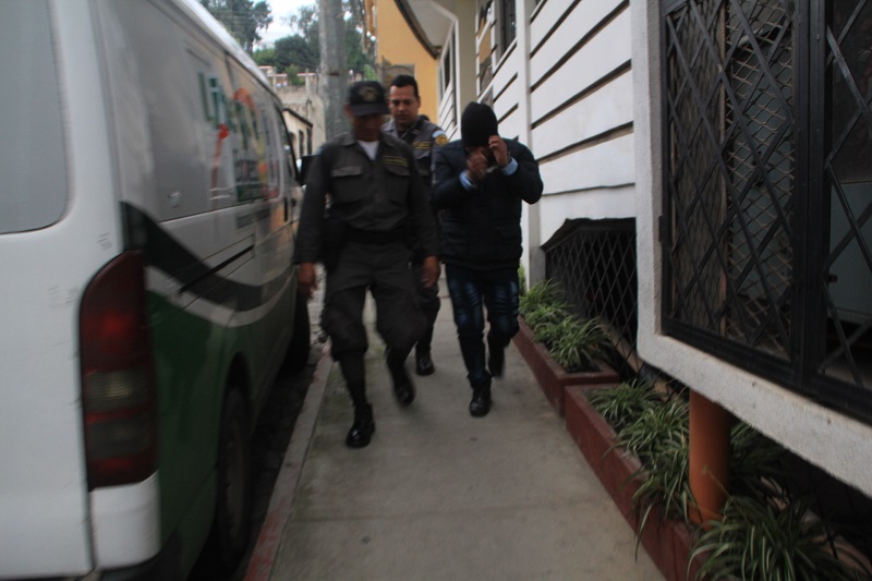 Juan Carlos Bixcul Peneleu, derecha, es custodiado por guardias del Sistema Penitenciario cuando sale del Tribunal de Sentencia de Femicidio de Sololá. (Foto Prensa Libre: Ángel Julajuj)
