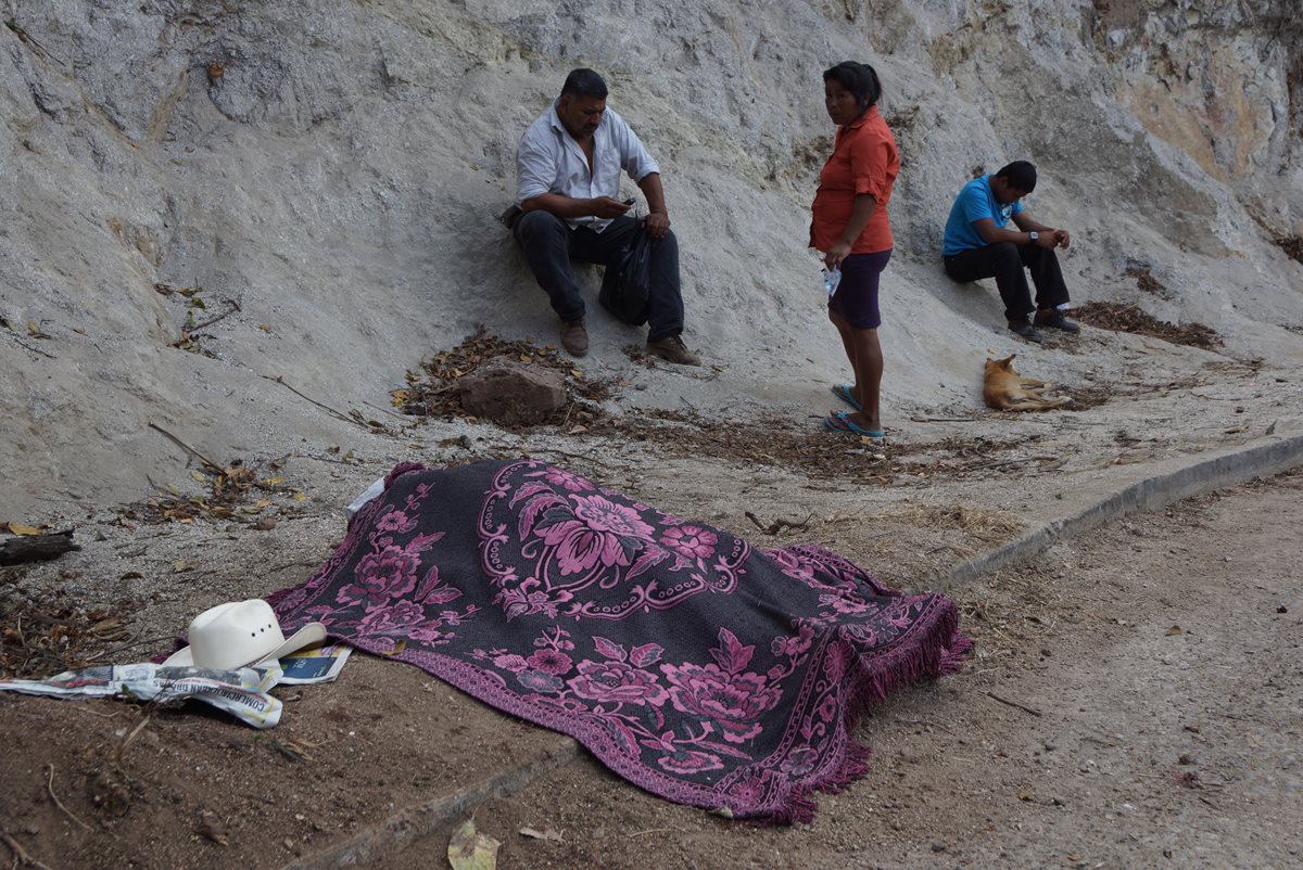 El cadáver de Ramos permanece cubierto junto a su sombrero en el lugar del ataque. (Foto Prensa Libre: Mario Morales)