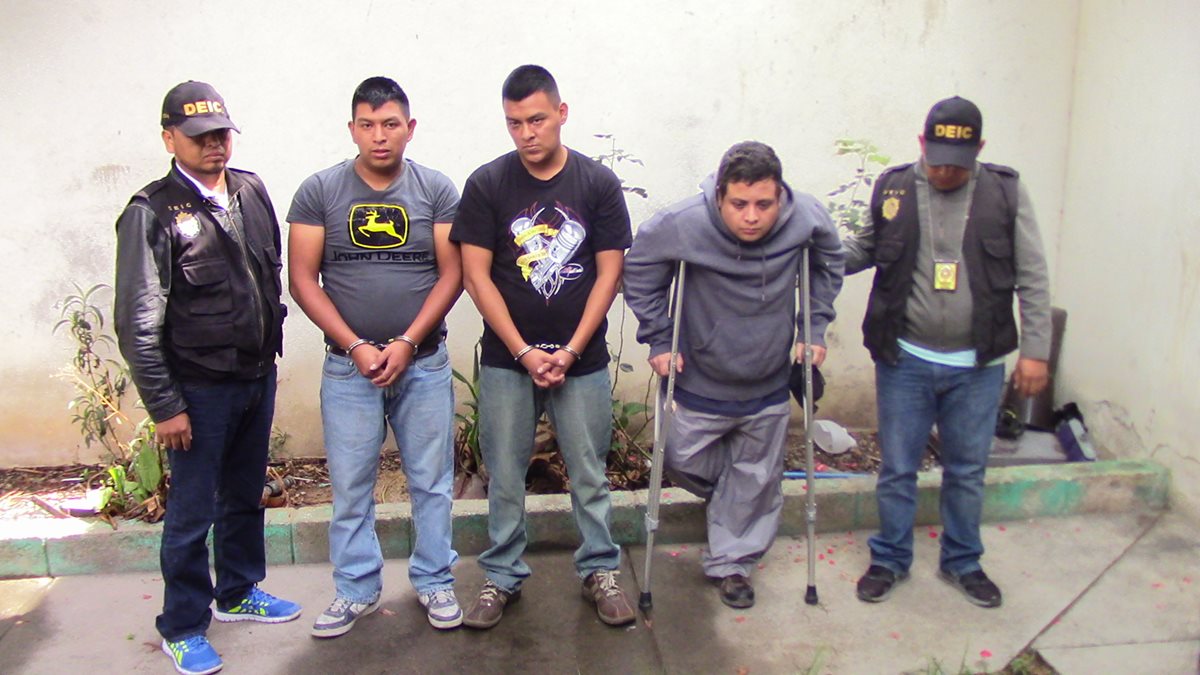 Los tres aprehendidos en Huehuetenango son custodiados por agentes de la PNC. (Foto Prensa Libre: Mike Castillo)