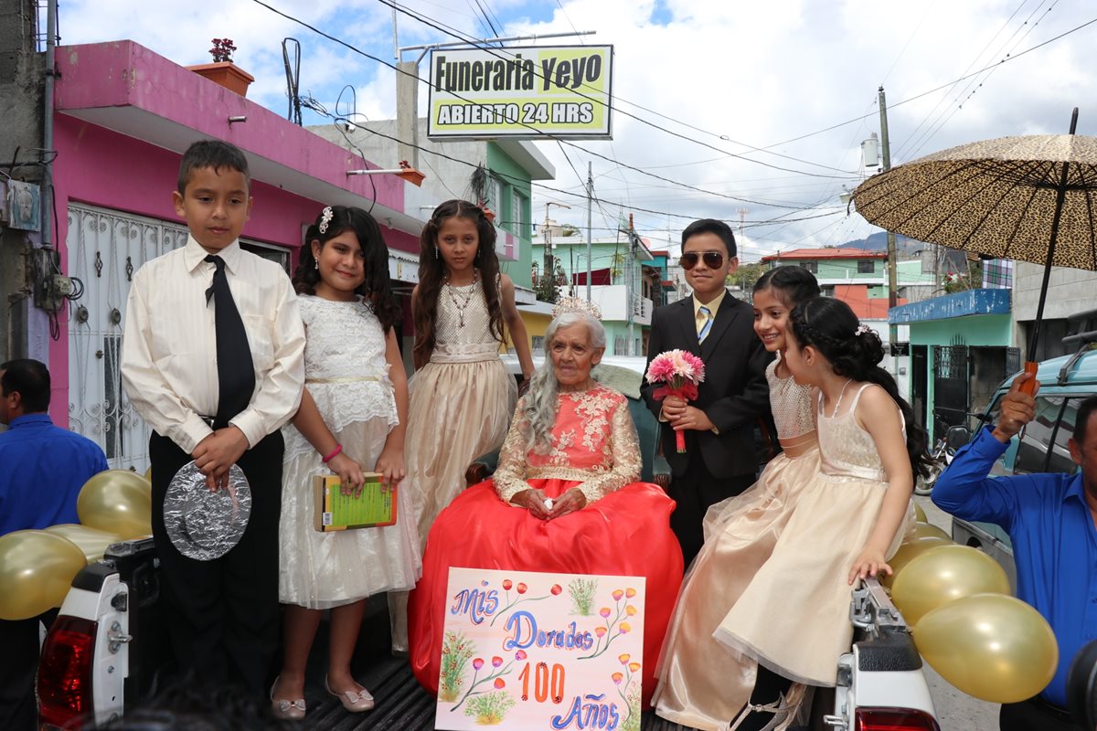 Nietos y bisnietos acompañan a Juventina Rodríguez en la carroza en la que recorrió calles de Pachalum. (Foto Prensa Libre: Héctor Cordero)