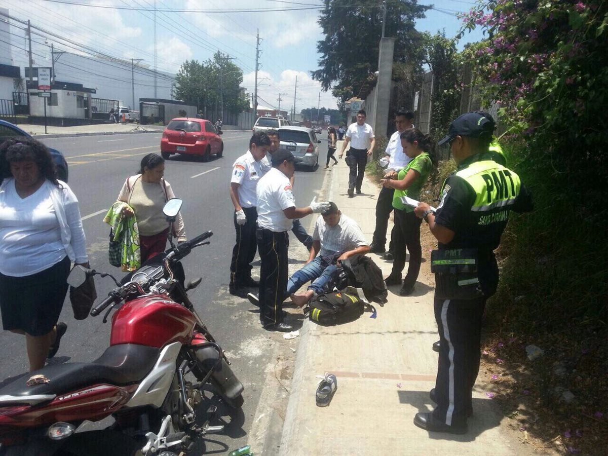 Bomberos Voluntarios atienden a un herido que viajaba en motocicleta después de un percance. (Foto Prensa Libre: CBV)