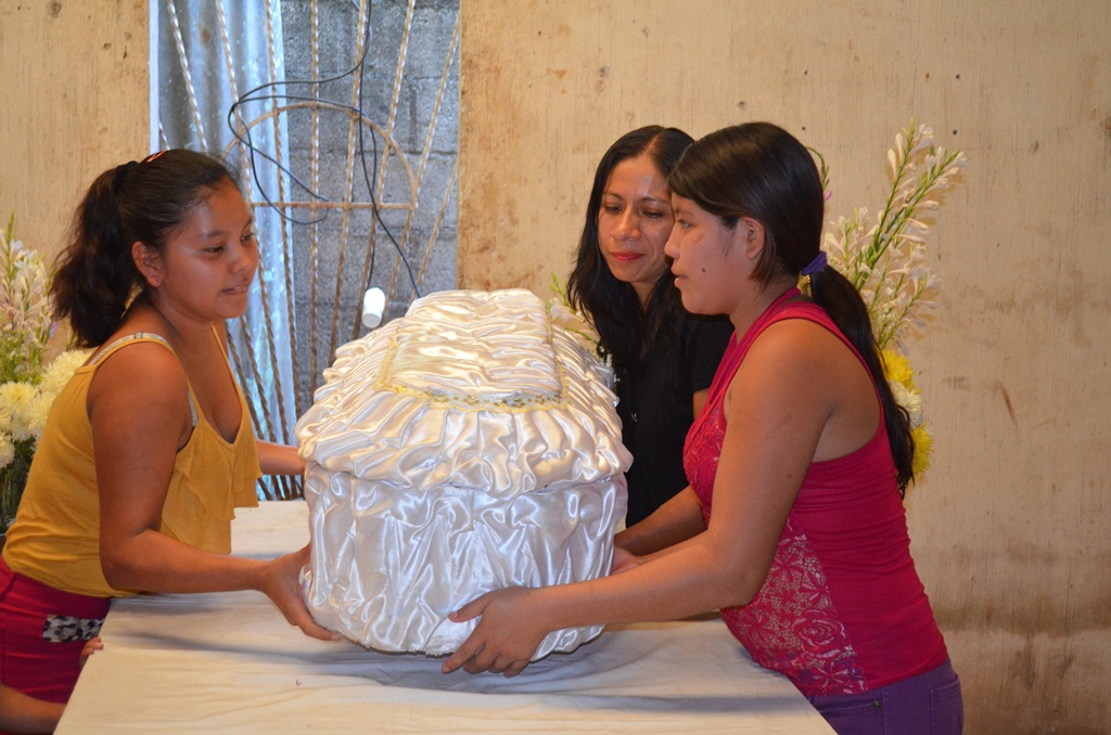 Vecinas cargan el ataúd que contiene los restos de la menor. (Foto Prensa Libre: Jorge Tizol).