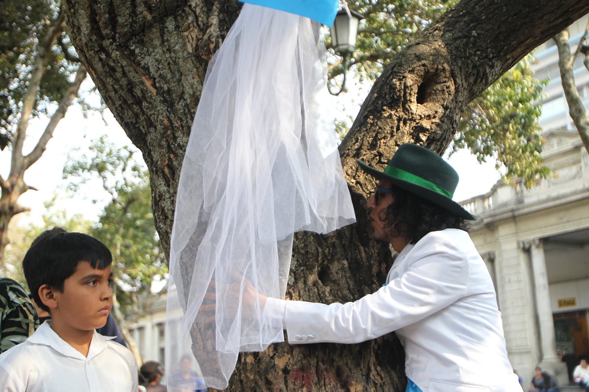 El actor peruano Richard Torres besa a un árbol de la Plaza de la Constitución al que se unió en una boda simbólica para pedir la reforestación de Guatemala. (Fotos Prensa Libre, Érick Ávila)