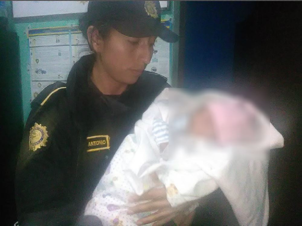 Una agente policial sostiene a la bebé que fue abandonada en un predio de vehículos de Esquipulas, Chiquimula. (Foto Prensa Libre: Mario Morales)