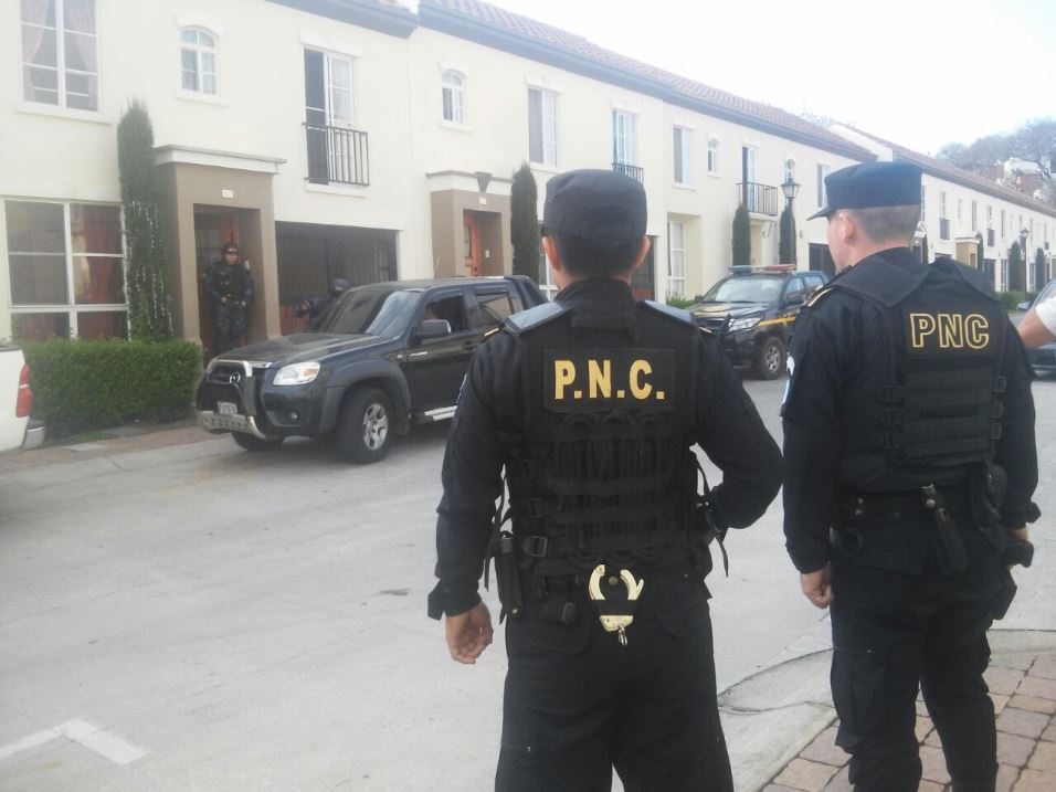 Policías resguardan las afueras de una vivienda en la zona 4 de Mixco donde se efectuó un operativo. (Foto: PNC)