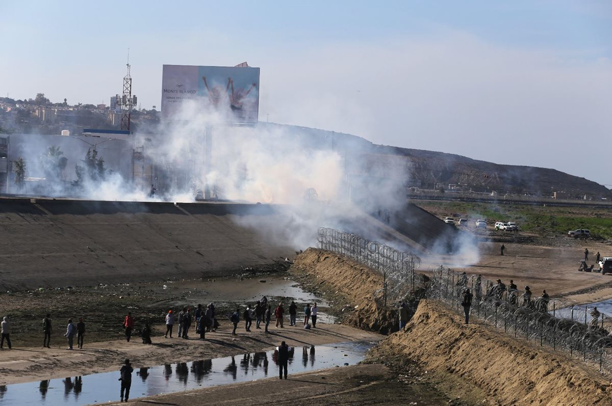 La fuerzas de seguridad lanzaron gas a los migrantes que intentaron cruzar por la fuerza. (Foto Prensa Libre: EFE)