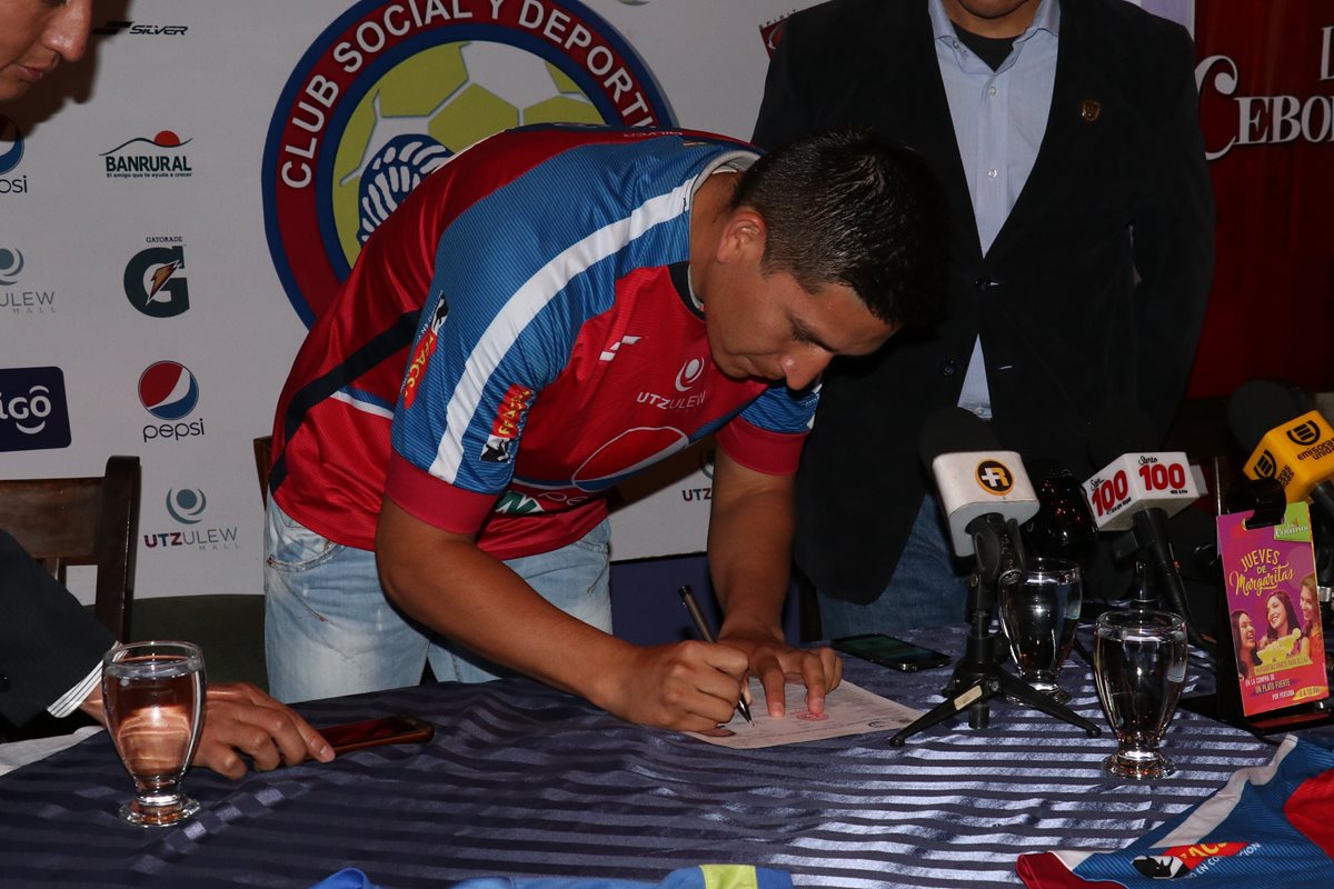 Vladimir Castellón firma el contrato que lo vincula por un año con Xelajú MC. (Foto Prensa Libre: Raúl Juárez)