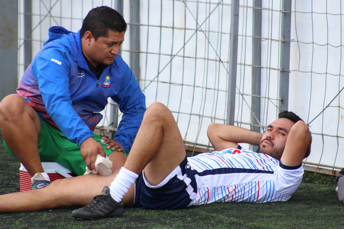 El fisioterapeuta de Xelajú, Henry Velásquez, realiza trabajo de masaje a Carlos Kamiani luego del trabajo de este jueves. (Foto Prensa Libre: Raúl Juárez)