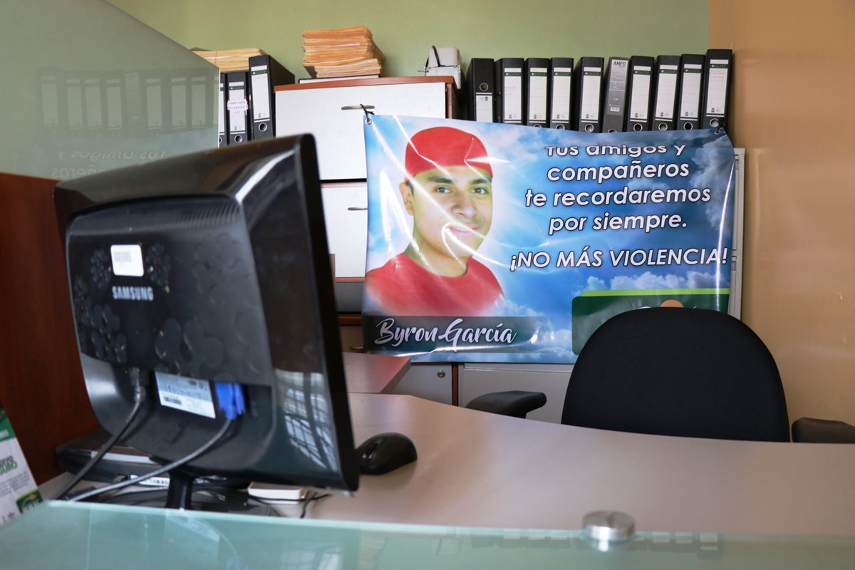 La oficina de Byron Crisóstomo García permanece vacía. Sus compañeros de trabajo colocaron una pancarta con su fotografía. (Foto Prensa Libre: Mario Morales)