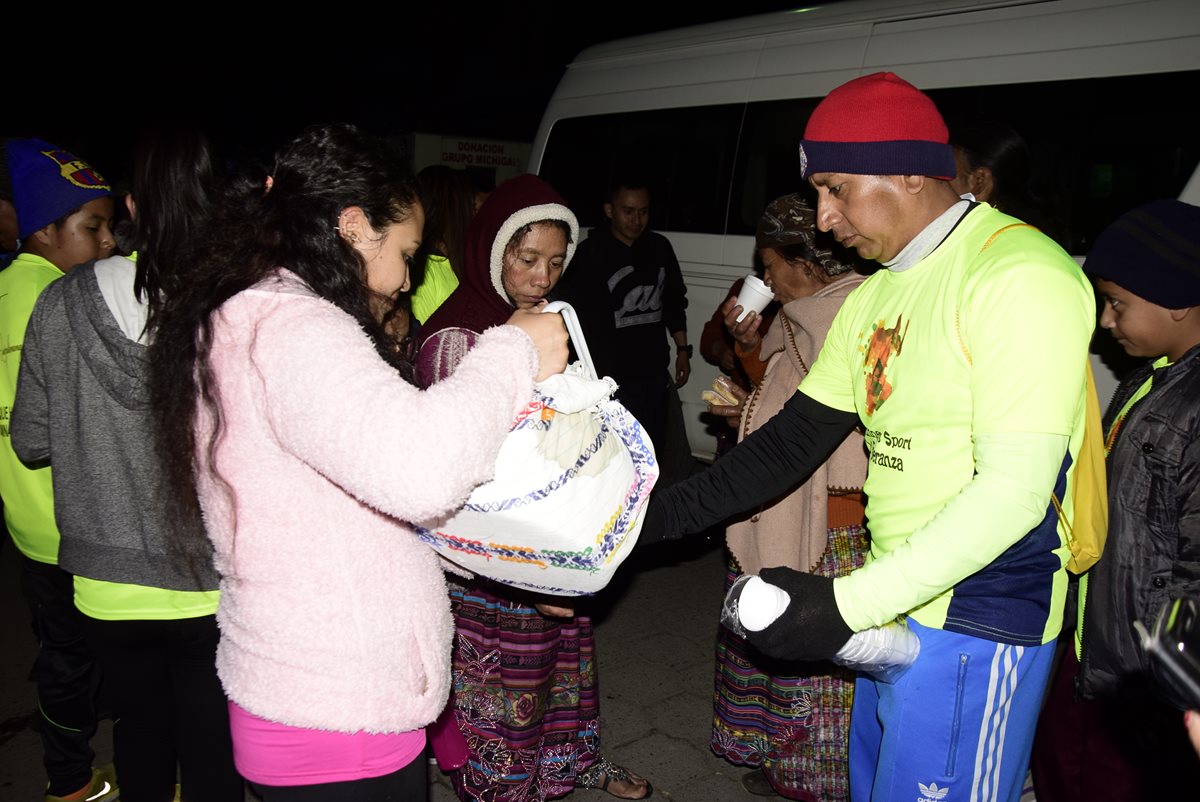 Los deportistas entregan café y pan a los familiares de los pacientes en el Hospital Regional de Quetzaltenango. (Foto Prensa Libre: Raúl Juárez)