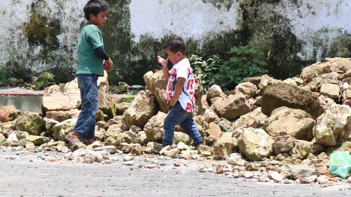 Dos niños caminan frente a los escombros de la iglesia de Samayac, la cual, en parte, cedió a la fuerza del sismo. (Foto Prensa Libre: Cristian Icó)